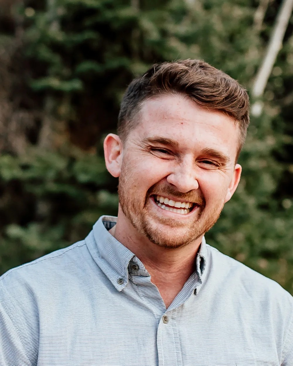 Dr. Brock Bennion, DDS, laughing outdoors — a warm candid of the Old Betsy Dental co-owner